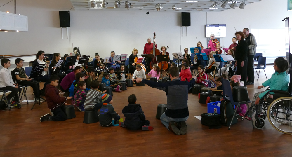 kinderen van Turkse muziekschool Elele, uit het AZC en van strijkorkest J!AS spelen samen; generale repetitie o.l.v. slagwerker Joep Everts op AZC Arnhem